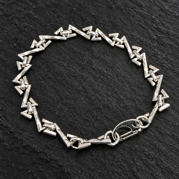 Bracelet chaîne à maillons triangulaires sur fond sombre