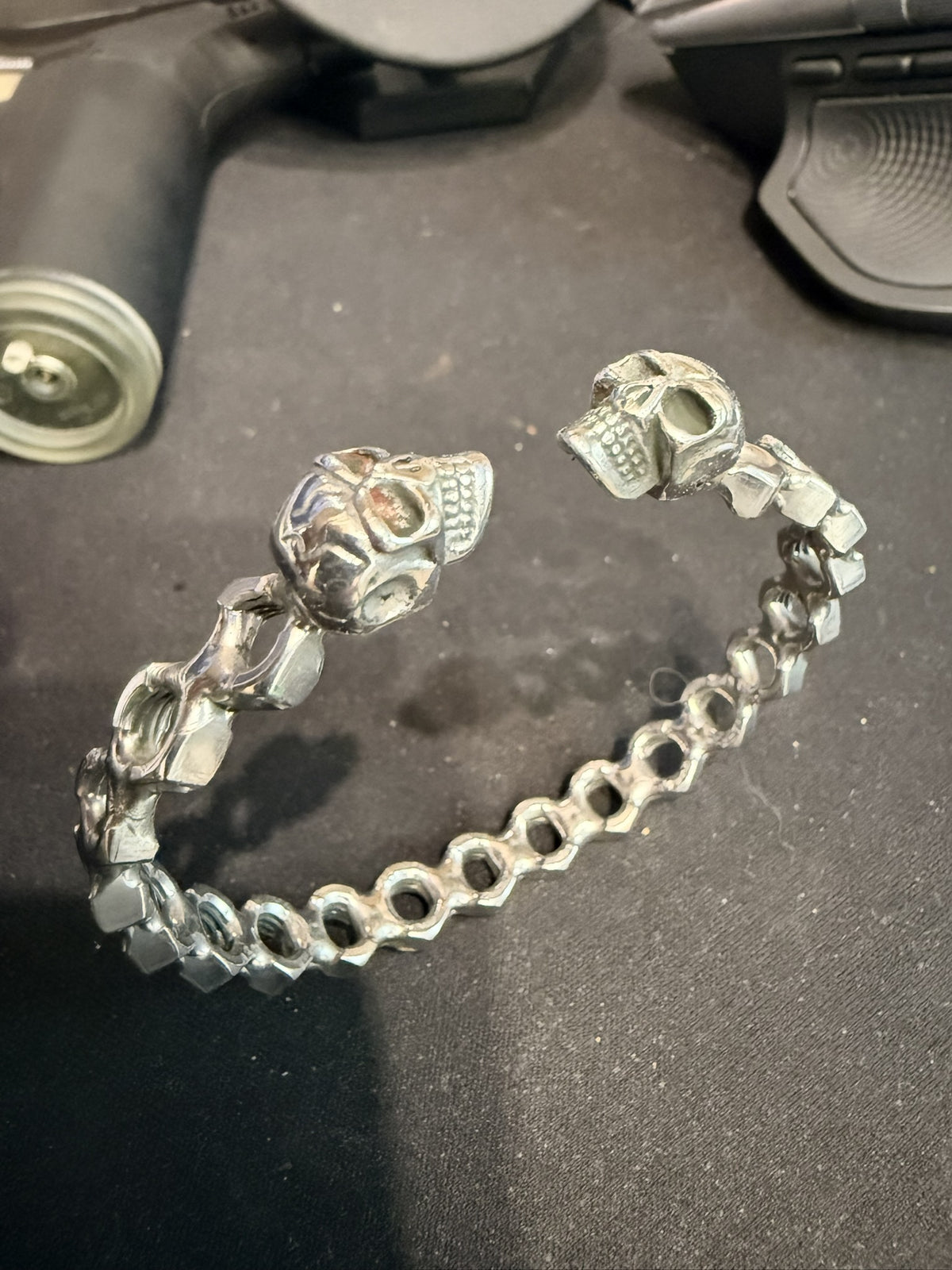Bracelet jonc écrous ajourés et deux crânes — Une rangée — photo originale de l’atelier