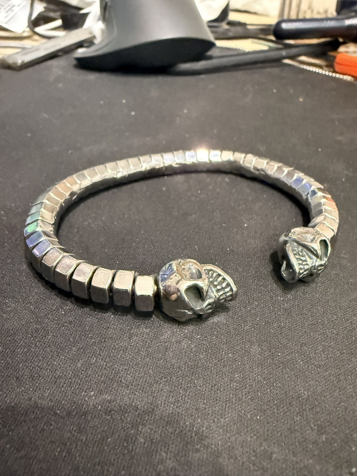 Bracelet jonc écrous alignés et deux crânes — photo originale de l’atelier