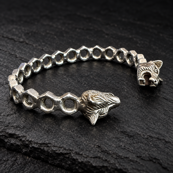 Bracelet jonc écrous et deux têtes de loup sur fond sombre