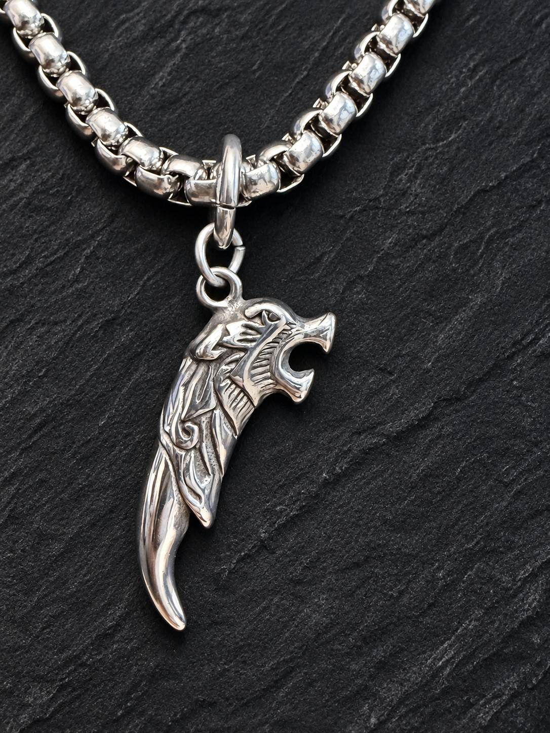 Collier tête de félin et griffe — gros plan sur ardoise noire