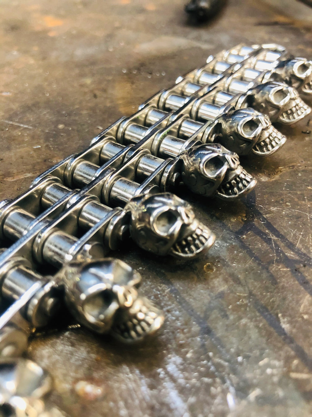 Détail du bracelet chaîne moto à rouleaux et têtes de mort alignées, Vito Art Métal — photographie originale