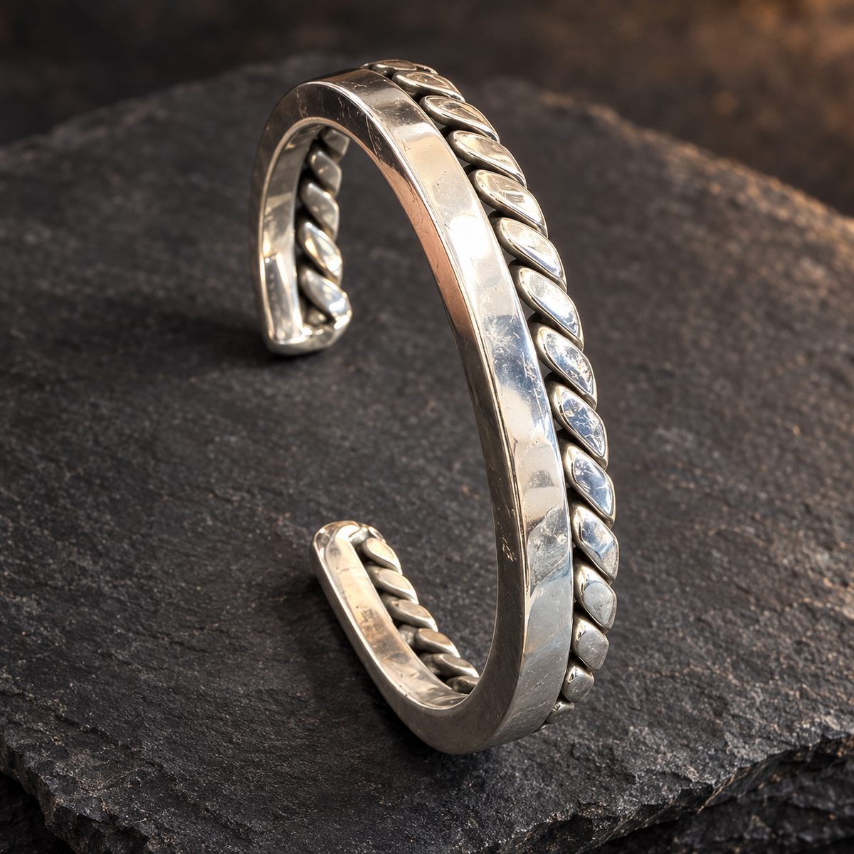 Bracelet jonc ouvert en inox 316L associant un carré plein poli et une rangée de maillons sur pierre sombre