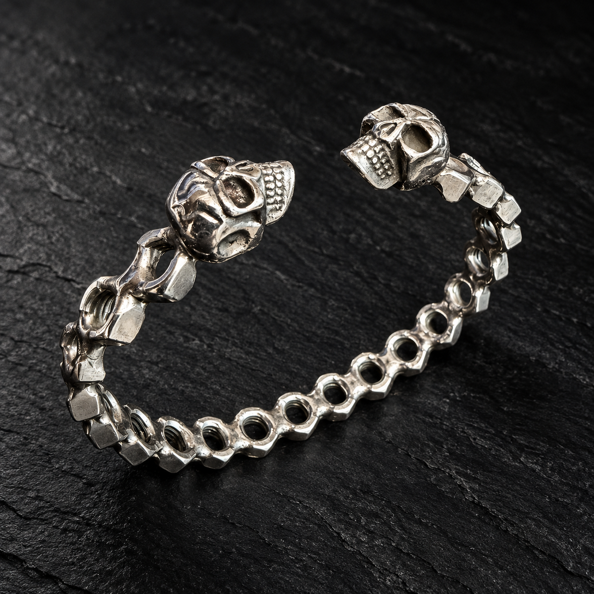 Bracelet jonc écrous ajourés et deux crânes — Une rangée sur fond sombre