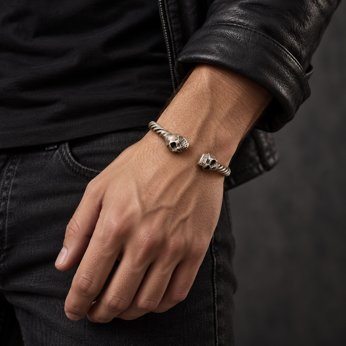 Bracelet jonc torsadé et deux têtes de mort porté au poignet