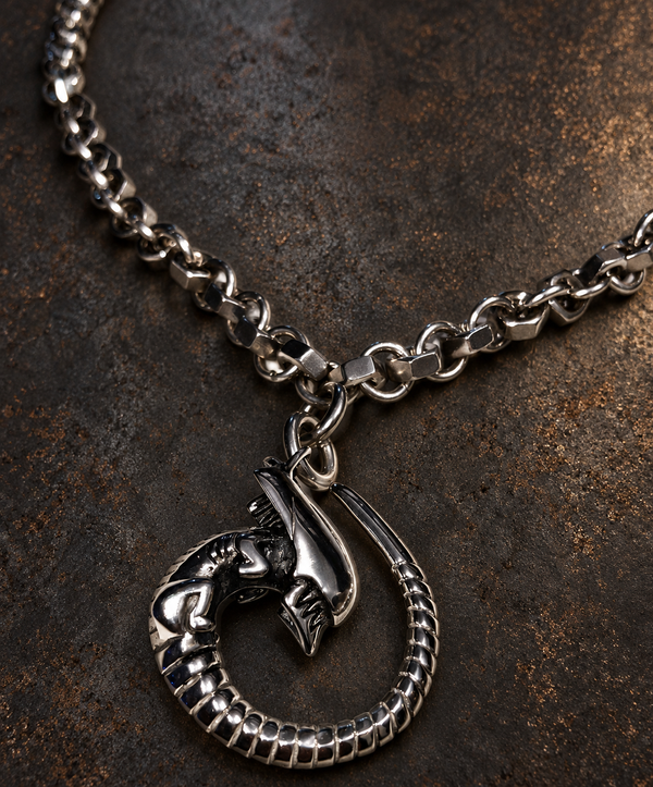Pendentif Alien à queue enroulée sur un collier composé d’écrous et d’anneaux métalliques