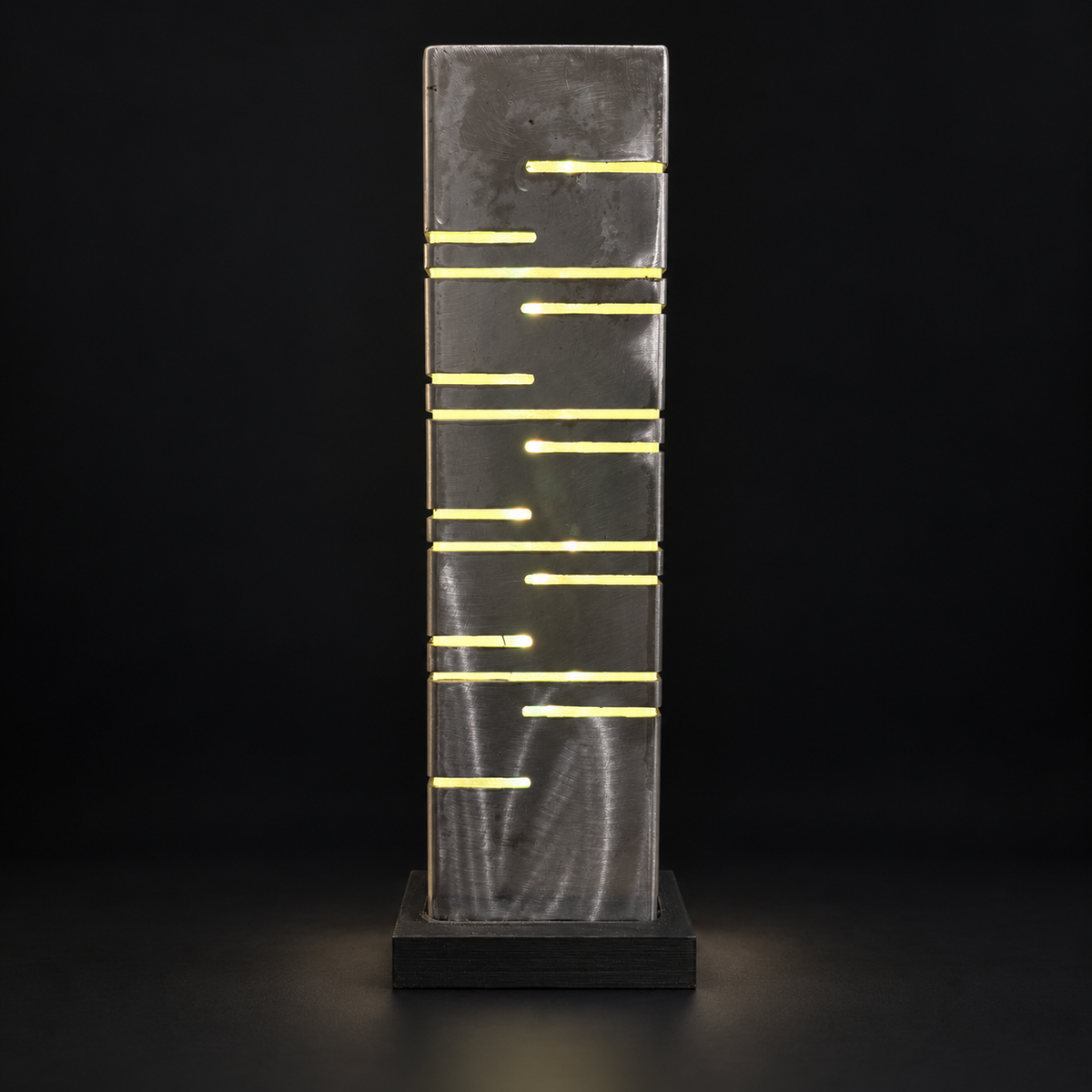 Deuxième face de la lampe LED en métal, découpes horizontales sur fond noir