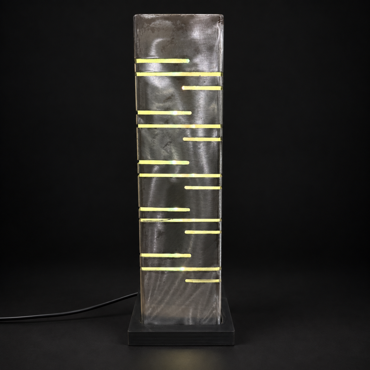 Quatrième face de la lampe LED en métal, motif de découpes sur fond noir